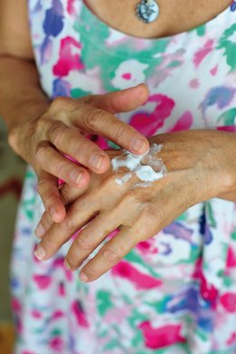 Manos de mujer aplicando crema para manos