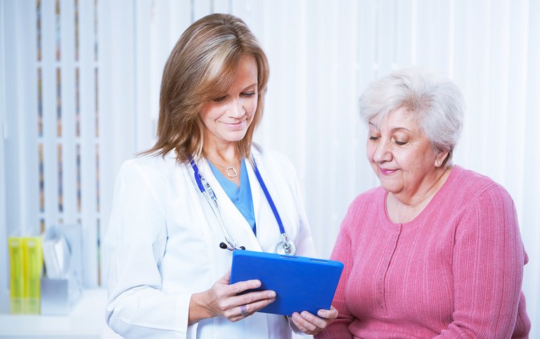 Médico y paciente mirando una tableta