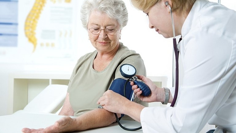 Médico tomando la tensión arterial a una mujer