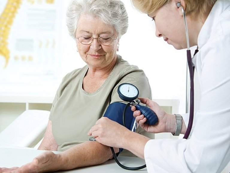 Médico tomando la tensión arterial a una mujer